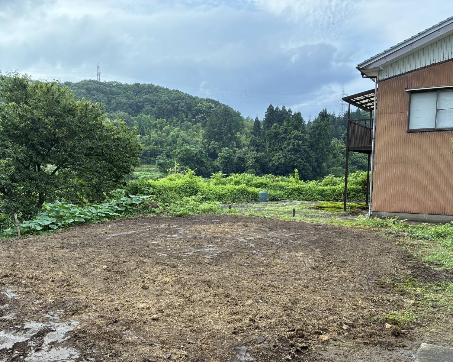 解体後に平らにならされた更地。奥に山と木々が見える