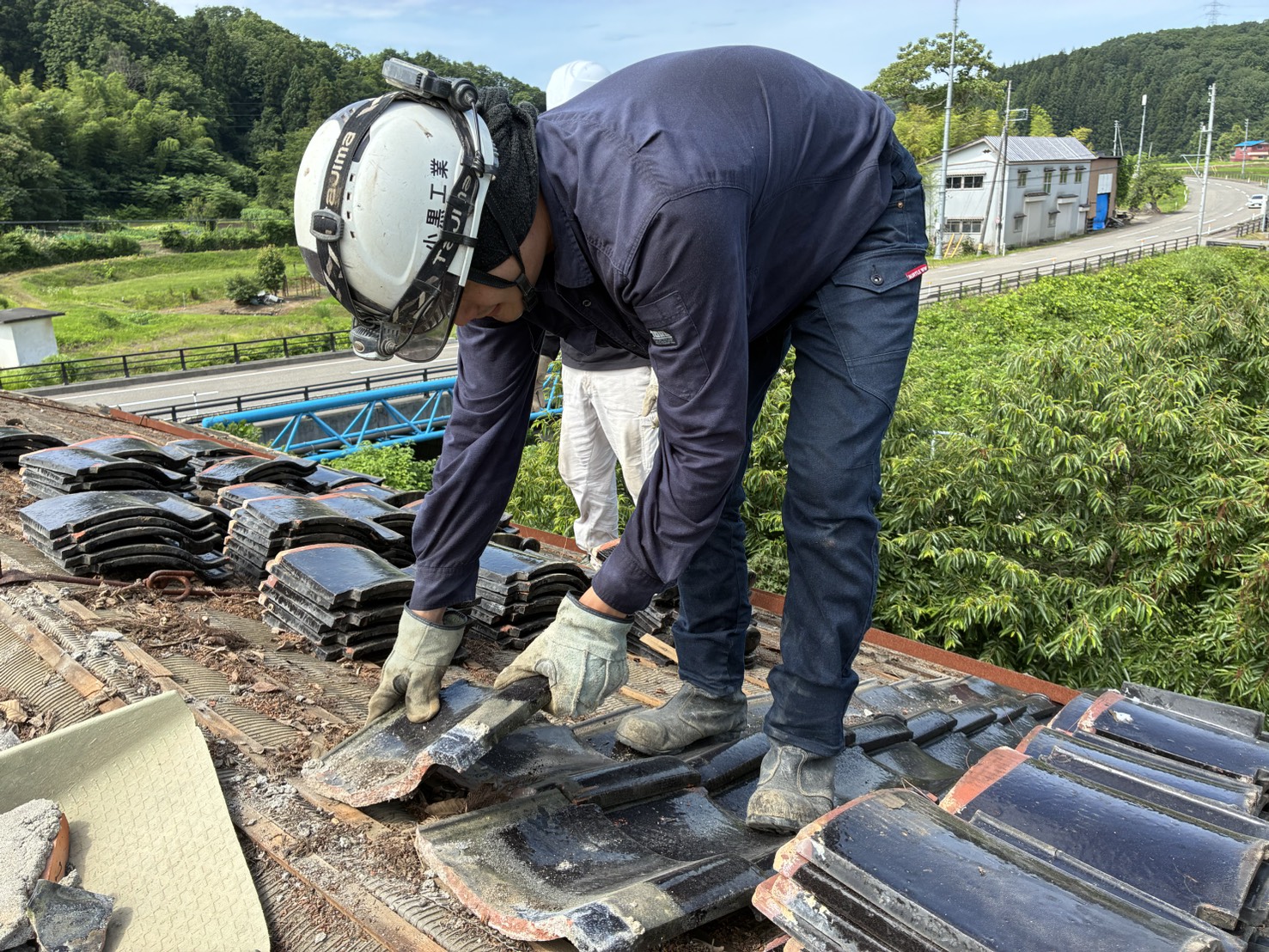 屋根に登って瓦をはがしているところ