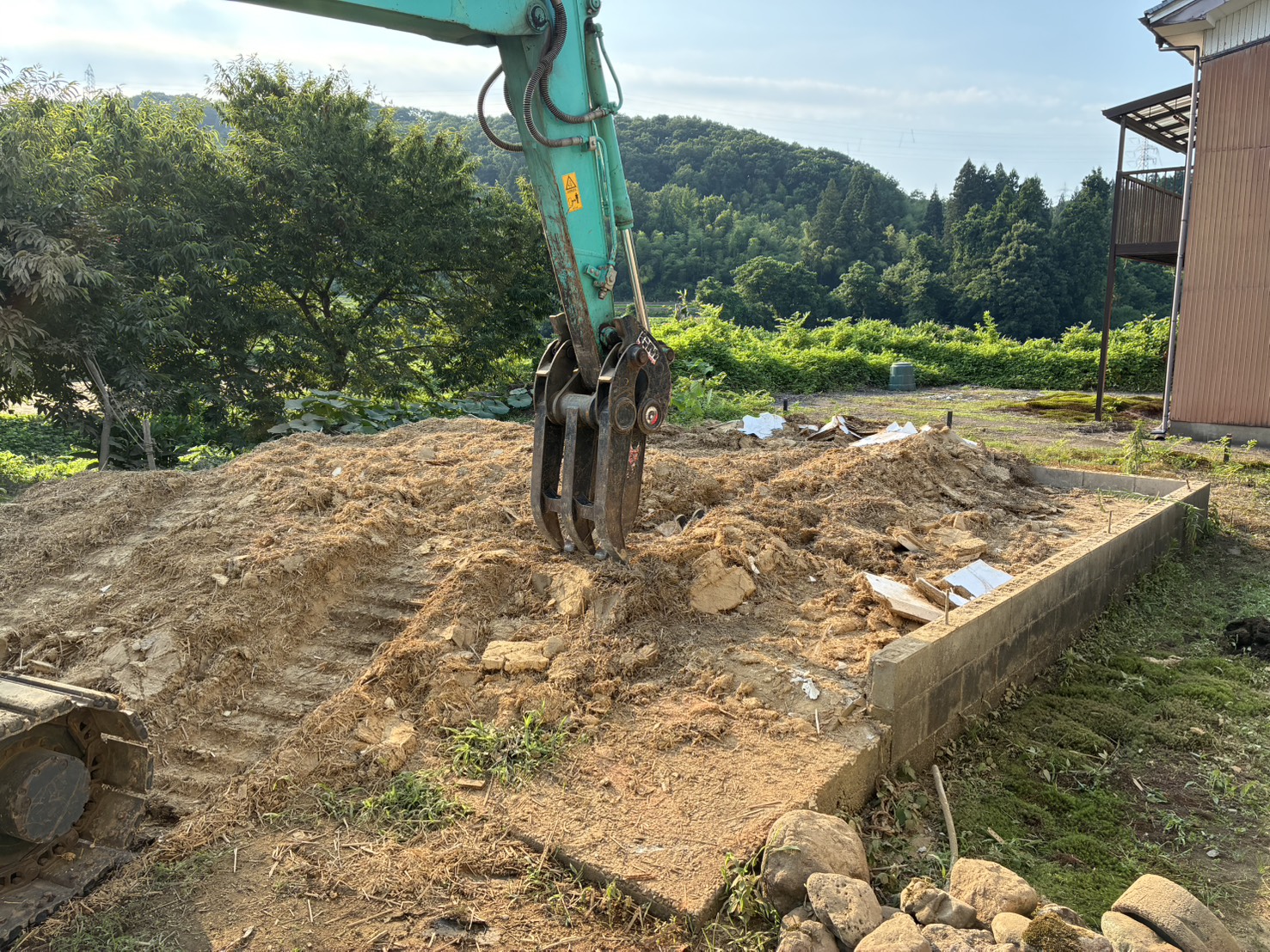 重機で土壁だった土の山をならしているところ